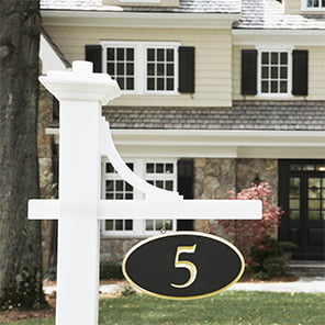 Couple standing in front of a home with their around eachother while viewing the front of the house