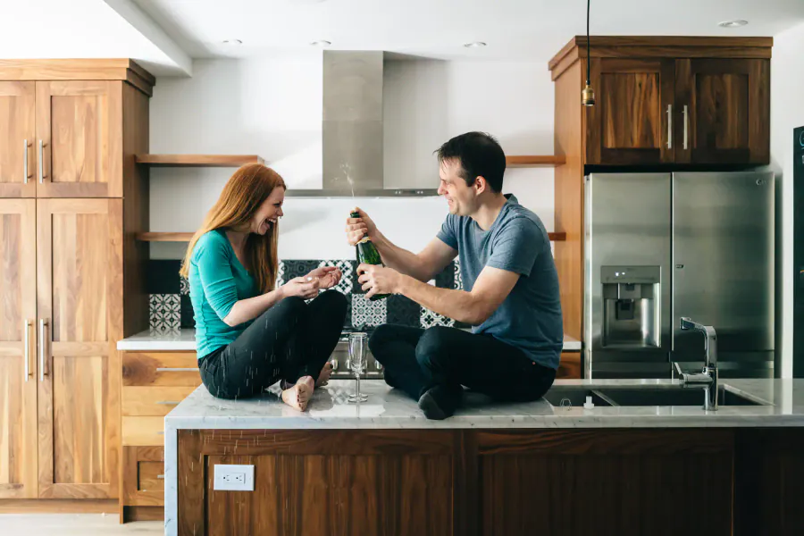 Couple sitting on the kitchen counter of their new home